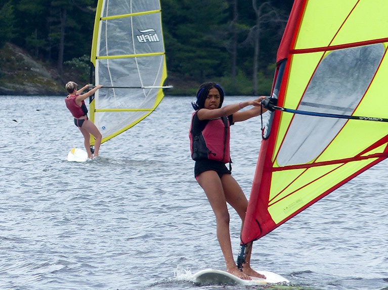 campers windsurfing on lake